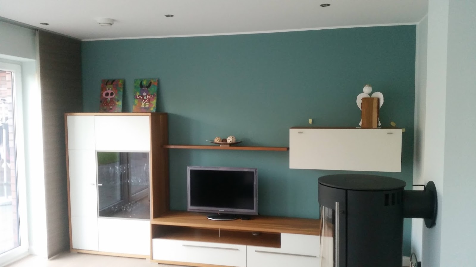 Wohnzimmerwand in Petrol mit Kaminofen